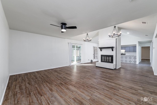 unfurnished living room with lofted ceiling, ceiling fan with notable chandelier, and dark hardwood / wood-style flooring