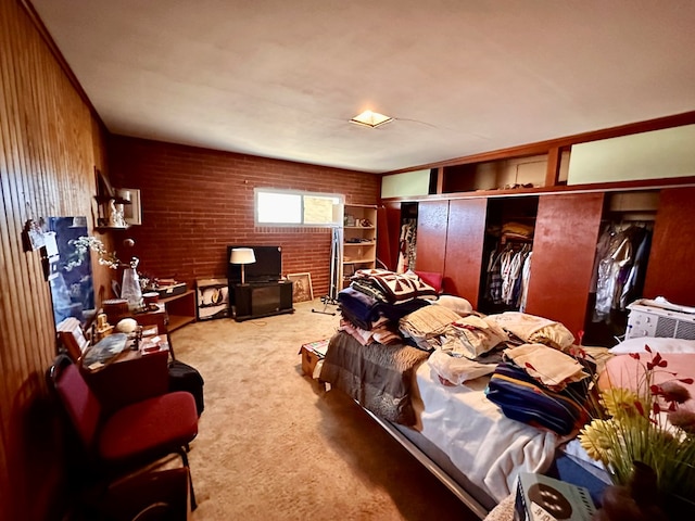 bedroom with a closet, light carpet, and wood walls