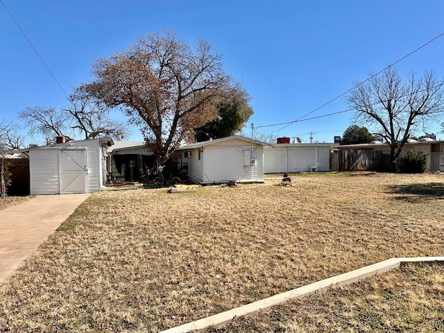 view of front of house with a front lawn and a storage unit