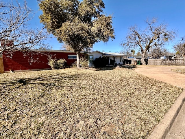 exterior space with concrete driveway and fence