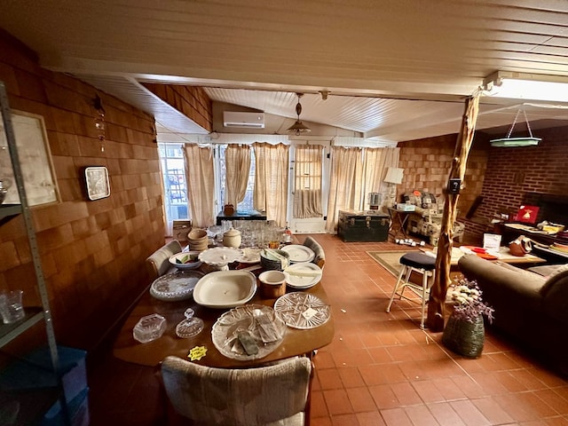 tiled dining space featuring brick wall, a wall mounted AC, and vaulted ceiling