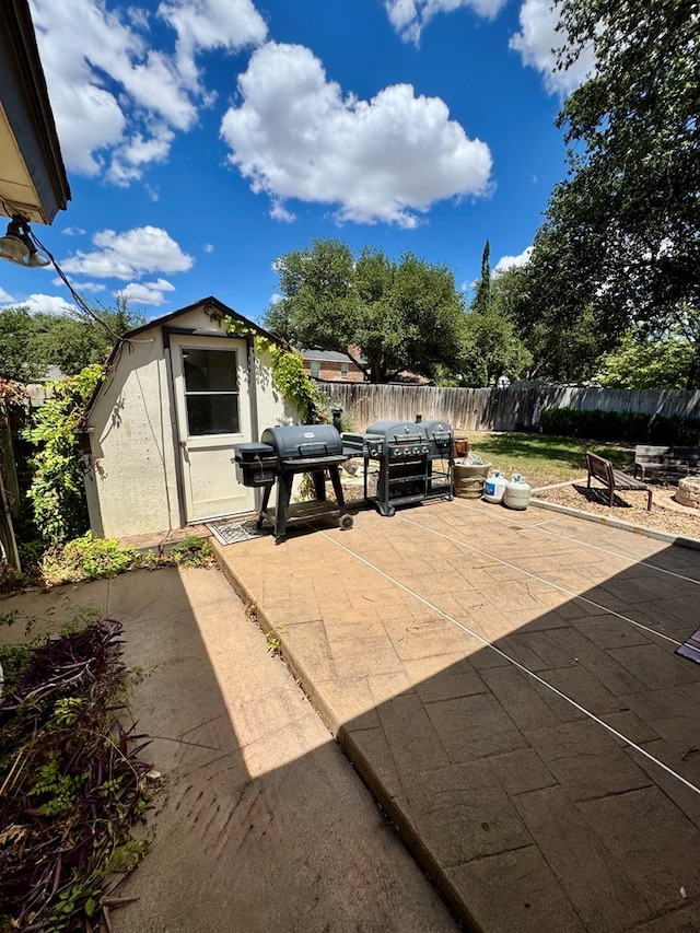 5214 Green Valley Trl, San Angelo, TX 76904 - fenced backyard featuring a patio, a storage unit, a grill, and outdoor dining space