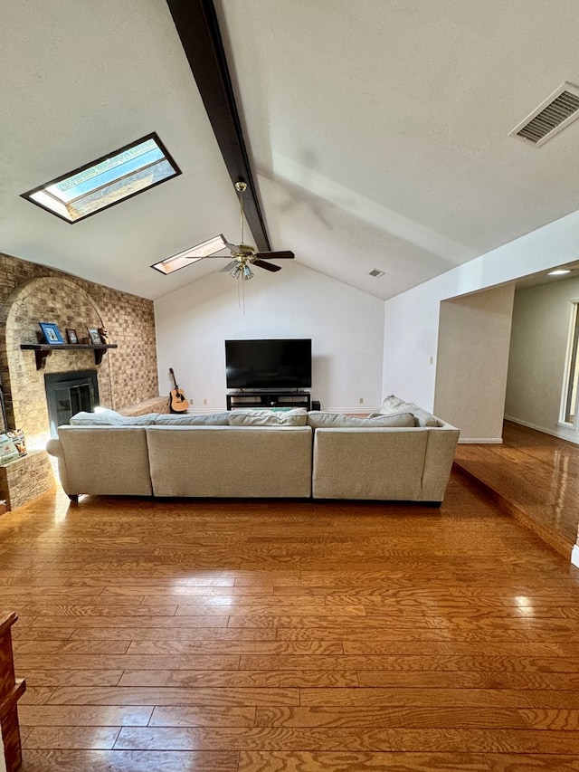 5214 Green Valley Trl, San Angelo, TX 76904 - living area with wood-type flooring, a skylight, ceiling fan, and a large fireplace
