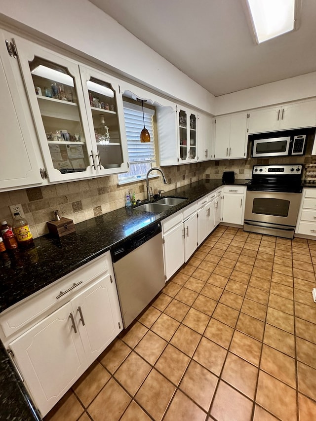 5214 Green Valley Trl, San Angelo, TX 76904 - kitchen with stainless steel appliances, tasteful backsplash, white cabinetry, glass insert cabinets, and light tile patterned flooring