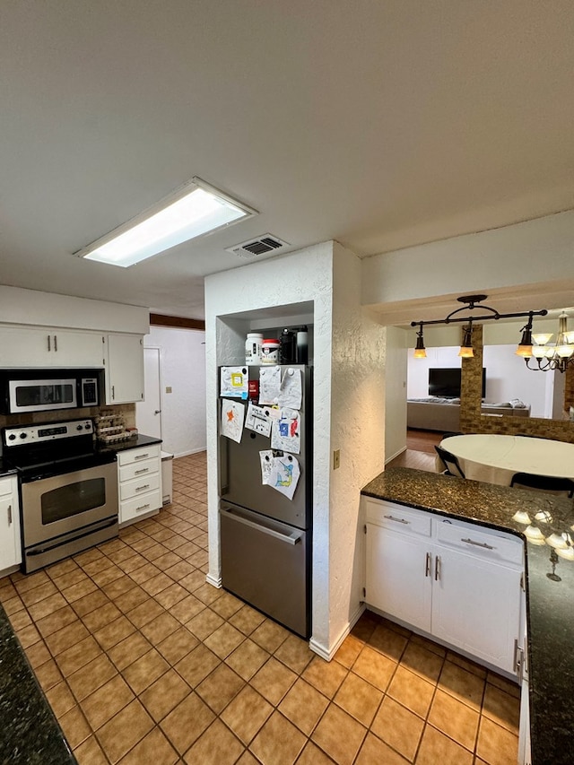 5214 Green Valley Trl, San Angelo, TX 76904 - kitchen with stainless steel appliances, white cabinetry, light tile patterned floors, and a textured wall