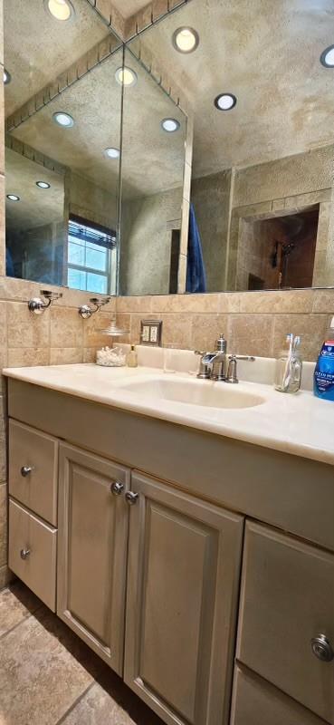 1210 Elizabeth St, Rankin, TX 79778 - full bath with double vanity, tile walls, and backsplash