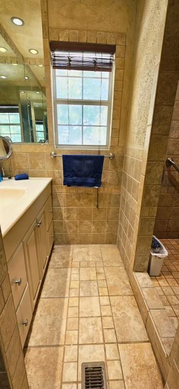 1210 Elizabeth St, Rankin, TX 79778 - bathroom with vanity, a tile shower, healthy amount of natural light, and recessed lighting