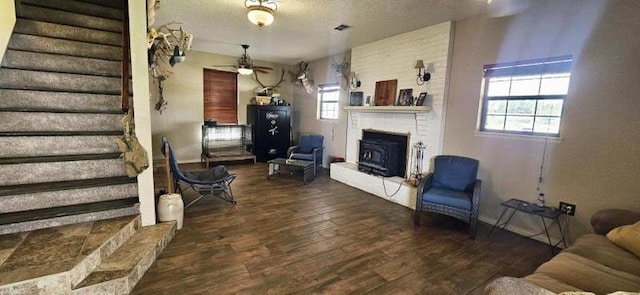 1210 Elizabeth St, Rankin, TX 79778 - living room with ceiling fan, wood finished floors, a fireplace with raised hearth, stairway, and a textured ceiling