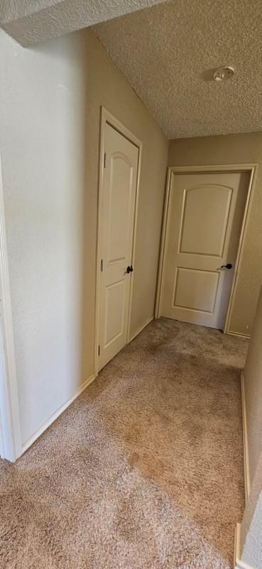 1210 Elizabeth St, Rankin, TX 79778 - corridor featuring carpet and a textured ceiling