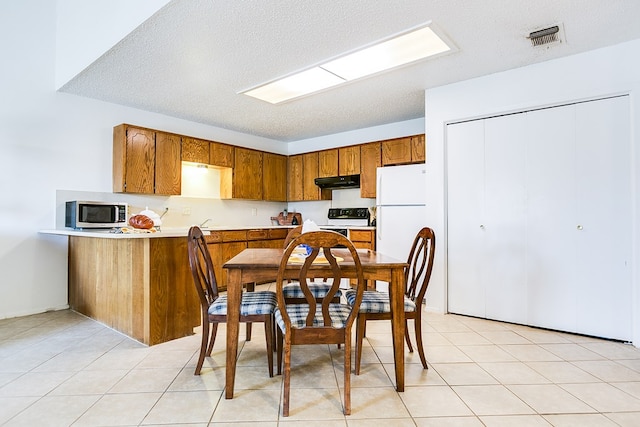 kitchen with light tile patterned floors, electric range, a textured ceiling, kitchen peninsula, and white fridge