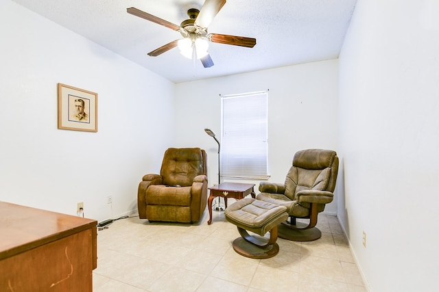 living area with a textured ceiling and ceiling fan