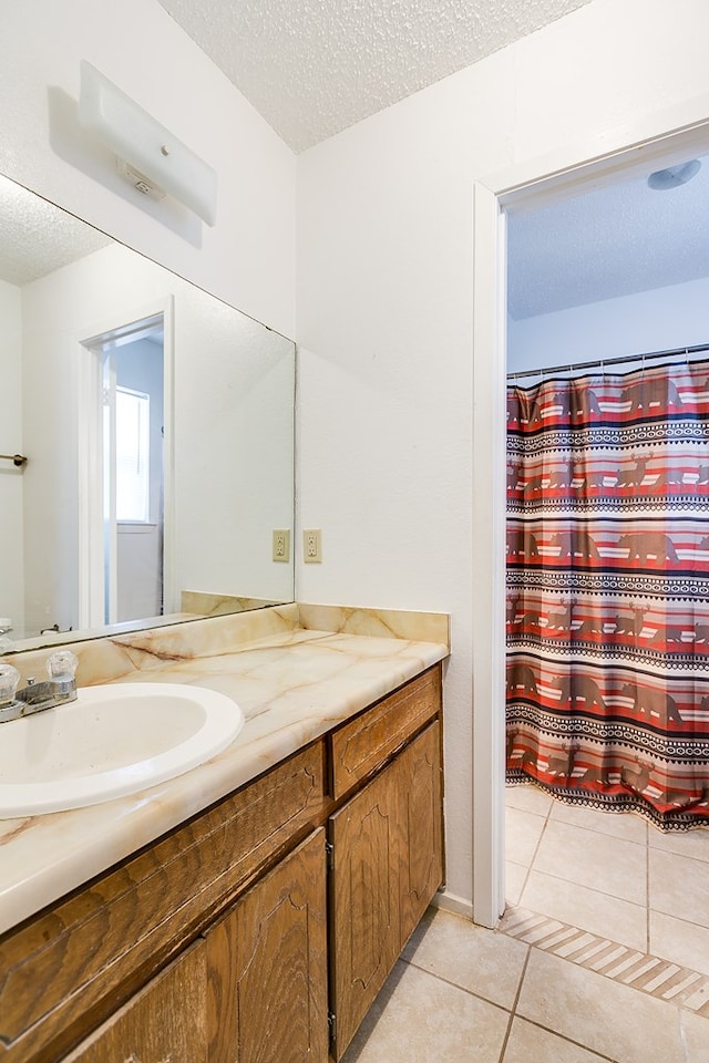 bathroom featuring tile patterned flooring, vanity, and a textured ceiling