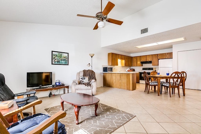 living room with a textured ceiling, ceiling fan, and light tile patterned flooring