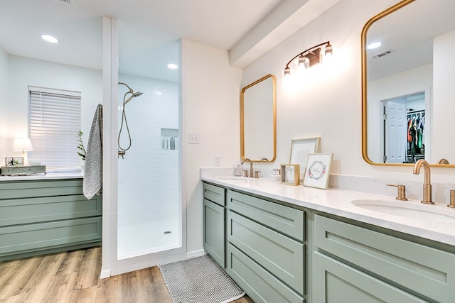 2805 Alta Vista Ln, San Angelo, TX 76904 - bathroom featuring a stall shower, double vanity, a spacious closet, recessed lighting, and wood finished floors