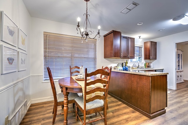 2805 Alta Vista Ln, San Angelo, TX 76904 - kitchen featuring a chandelier, dark wood-type flooring, a peninsula, pendant lighting, and dark brown cabinetry