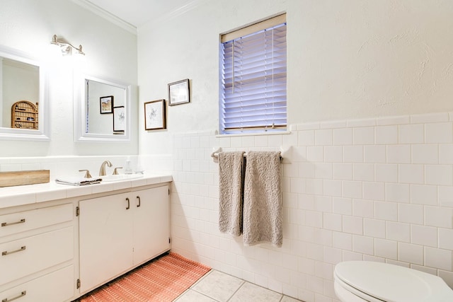 2805 Alta Vista Ln, San Angelo, TX 76904 - bathroom with tile walls, vanity, tile patterned floors, crown molding, and a wainscoted wall