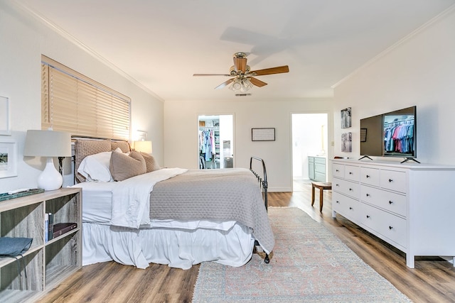 2805 Alta Vista Ln, San Angelo, TX 76904 - bedroom featuring crown molding, wood finished floors, a walk in closet, ceiling fan, and a closet