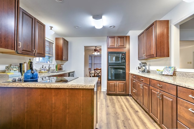 2805 Alta Vista Ln, San Angelo, TX 76904 - kitchen featuring black appliances, light wood-style flooring, a ceiling fan, and a peninsula