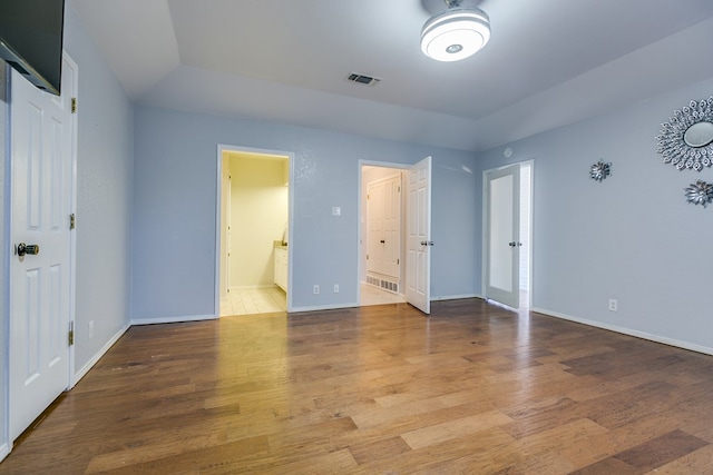 unfurnished bedroom with wood-type flooring and ensuite bathroom