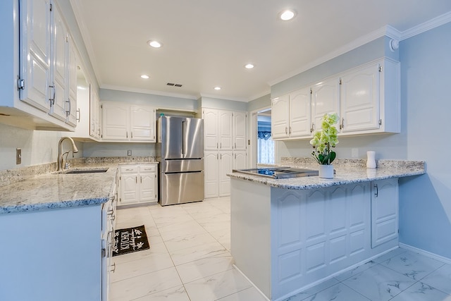 kitchen with stainless steel refrigerator, sink, white cabinets, light stone counters, and kitchen peninsula