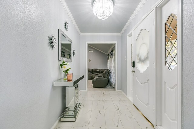 foyer entrance featuring ornamental molding and an inviting chandelier