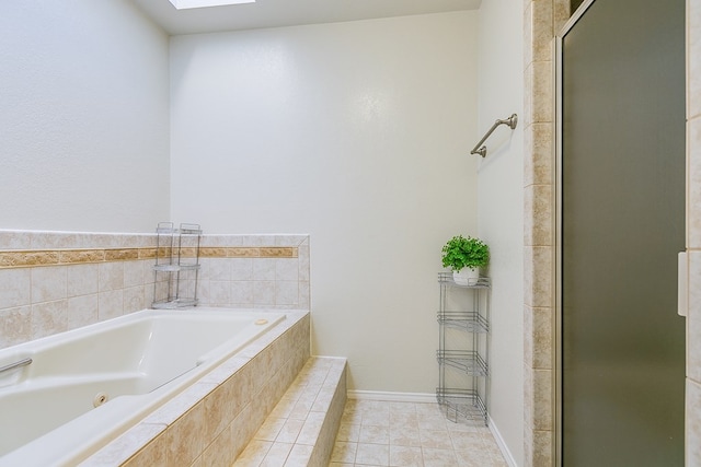 bathroom with a relaxing tiled tub, tile patterned floors, and a skylight