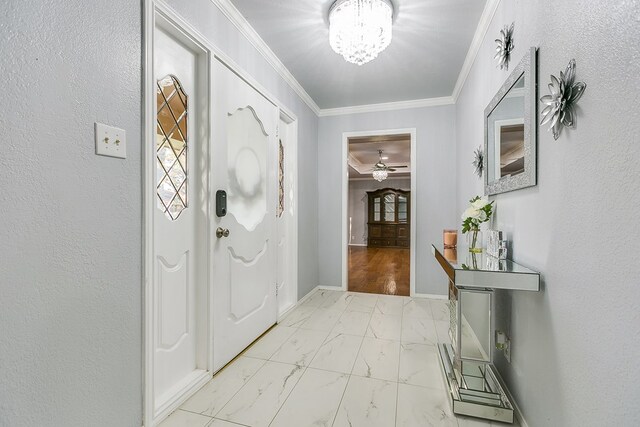 foyer with ornamental molding and a notable chandelier