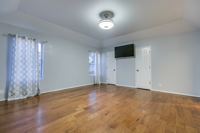 unfurnished room featuring hardwood / wood-style flooring and a raised ceiling