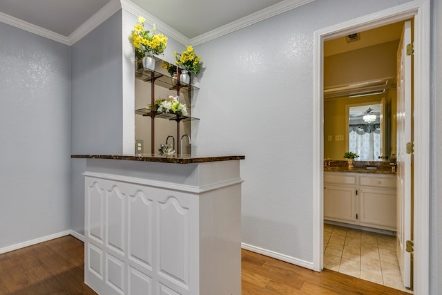 hallway with crown molding and light hardwood / wood-style floors