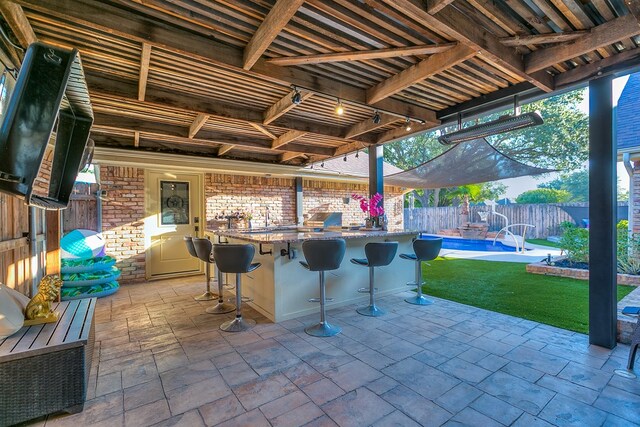 view of patio / terrace with a fenced in pool and exterior kitchen