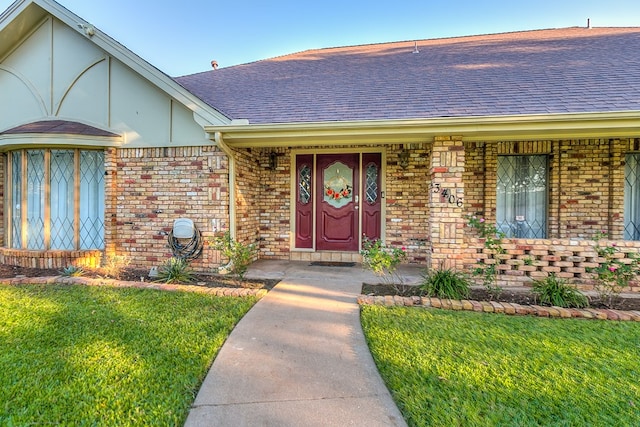 view of exterior entry with a yard