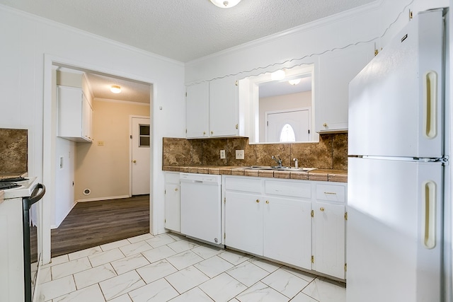 2410 Louise Dr, San Angelo, TX 76901 - kitchen featuring white appliances, crown molding, a sink, white cabinets, and decorative backsplash