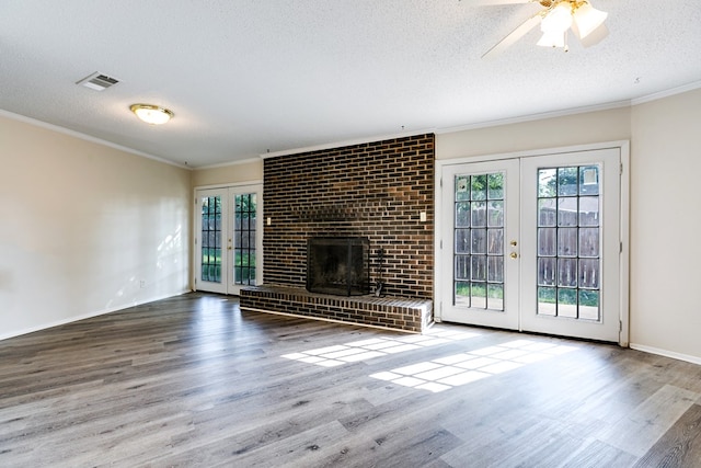 2410 Louise Dr, San Angelo, TX 76901 - unfurnished living room featuring french doors, plenty of natural light, a textured ceiling, wood finished floors, and crown molding