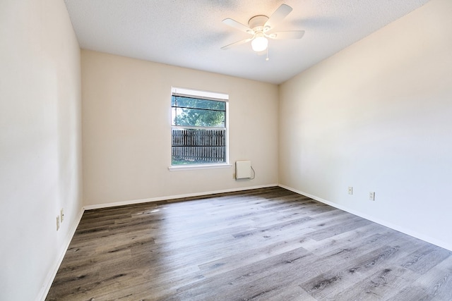 2410 Louise Dr, San Angelo, TX 76901 - unfurnished room with wood finished floors, a ceiling fan, baseboards, and a textured ceiling