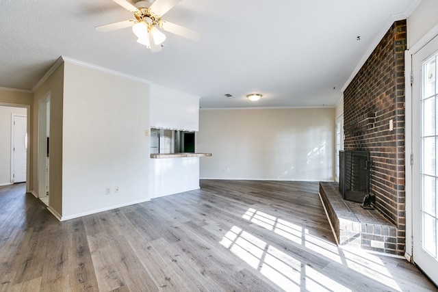 2410 Louise Dr, San Angelo, TX 76901 - unfurnished living room with a brick fireplace, wood finished floors, ornamental molding, ceiling fan, and baseboards