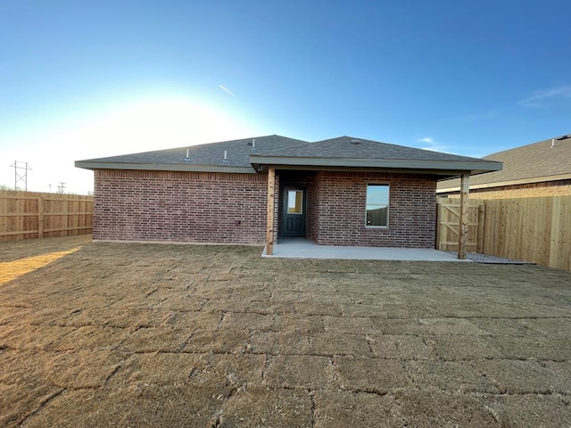 back of house featuring a patio area and a lawn