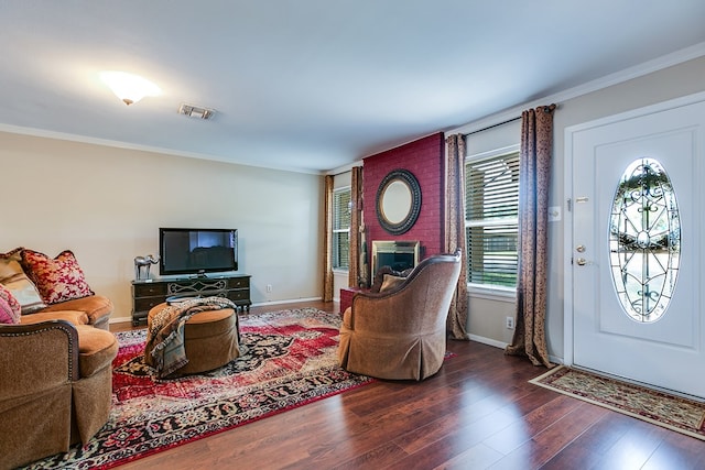 4918 Blue Ridge Trl, San Angelo, TX 76904 - living area featuring a brick fireplace, baseboards, wood finished floors, visible vents, and ornamental molding