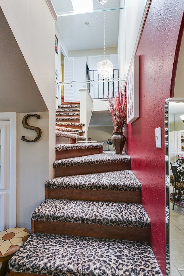 4918 Blue Ridge Trl, San Angelo, TX 76904 - staircase with tile patterned flooring and a chandelier