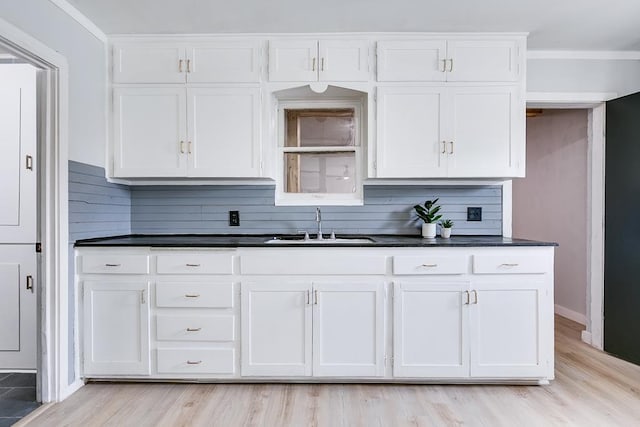 1016 N Campus Blvd, San Angelo, TX 76901 - kitchen with a sink, dark countertops, white cabinetry, and ornamental molding