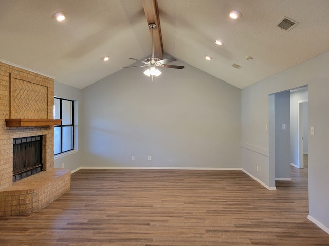 unfurnished living room with wood finished floors, visible vents, baseboards, lofted ceiling with beams, and a fireplace