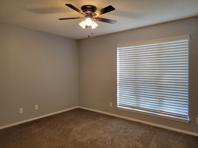 carpeted empty room with baseboards, a textured ceiling, and a ceiling fan