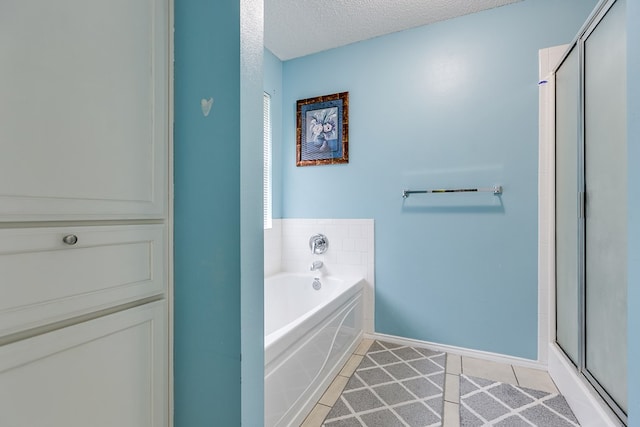 bathroom featuring tile patterned flooring, a textured ceiling, and separate shower and tub