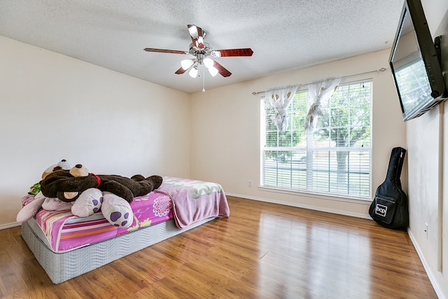 bedroom with wood-type flooring, a textured ceiling, and ceiling fan