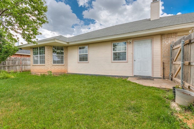 rear view of house featuring a lawn