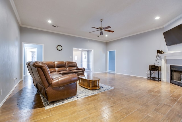 living room featuring crown molding, plenty of natural light, and ceiling fan