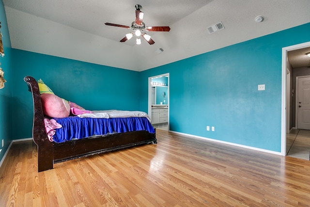 bedroom featuring lofted ceiling, connected bathroom, ceiling fan, and light hardwood / wood-style floors