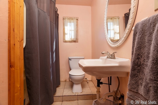 bathroom featuring tile patterned flooring, curtained shower, and toilet