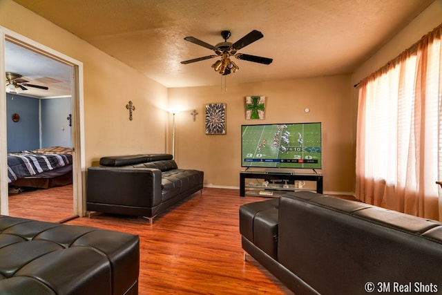 living room featuring hardwood / wood-style floors, a textured ceiling, and ceiling fan