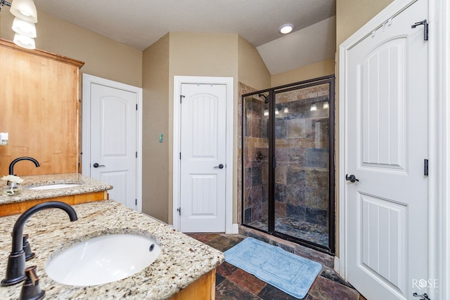 bathroom featuring lofted ceiling, vanity, and a shower with shower door