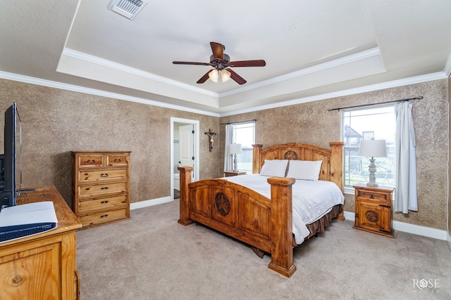 bedroom with ornamental molding, ceiling fan, and a tray ceiling